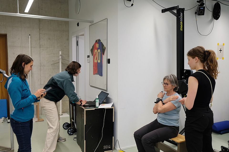 Our test subject during the sit-to-stand test, together with the INCLUDE team: Larissa Hänsli, Noemie Marti and Sierra Arn. 
